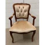 A mahogany style open armchair with buttoned back and upholstered seat
