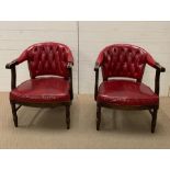 A pair of red leather library arm chairs, upholstered button back on oak tub frame