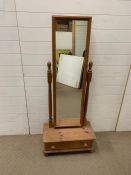 A pine free standing mirror on drawer base and bun feet