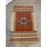 A red and cream rug with medallion design to center (152cm x 81cm)