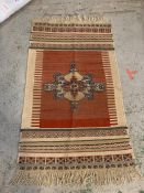 A red and cream rug with medallion design to center (152cm x 81cm)