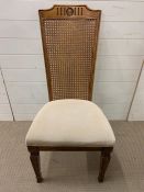 A hall chair with cane back and upholstered seat