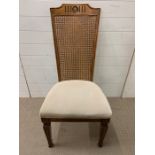 A hall chair with cane back and upholstered seat