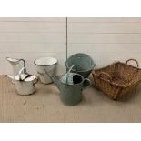 A selection of enamel and metal buckets and jugs, along with a wicker basket