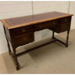 A leather topped writing desk on turned legs (H77cm W129cm D57cm)