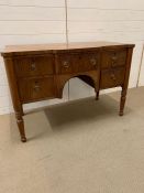 A dressing table on turned legs and four drawers to front (H77cm W115cm D55cm)
