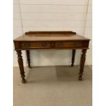 A regency style writing table on turned reeded and tapering legs (H79cm W106cm D58cm)