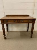 A regency style writing table on turned reeded and tapering legs (H79cm W106cm D58cm)