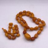 A graduated amber necklace (Approximately 69g) and an amber bracelet in need of repair (