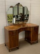 A dressing table flanked each side with cupboards and shaped mirror (H75cm W128cm D57cm)