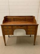 A mahogany Carlton house desk fitted with arrangement of drawers and square tapering legs (H98cm