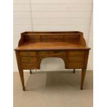 A mahogany Carlton house desk fitted with arrangement of drawers and square tapering legs (H98cm