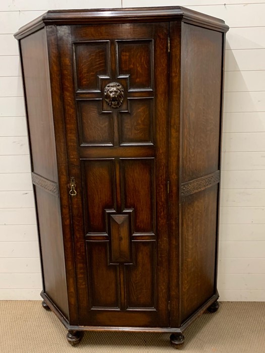 A oak hall cupboard/wardrobe with carved lion head decoration