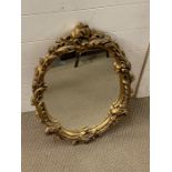 A gilt oval mirror