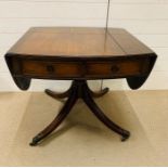 A mahogany style sofa table with twin hinged ends on a carved stem and four down swept legs with