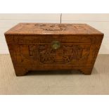 A Camphorwood chest with carved scenes of a prade flanked by two dignitary's