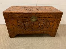 A Camphorwood chest with carved scenes of a prade flanked by two dignitary's