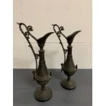 A pair of metal jugs with bronze patina on bases