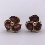 A Pair of three stone garnet earrings on hallmarked 9ct gold (Size L)