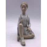 A Lladro figure of a seated girl with flowers