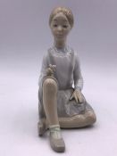 A Lladro figure of a seated girl with flowers