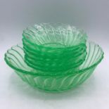 Seven uranium green glass bowls comprising of one larger/serving bowl and six dessert bowls