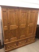 A three door pine wardrobe with three drawers under (H 190 cm x d 58 cm x W 178 cm)
