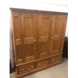 A three door pine wardrobe with three drawers under (H 190 cm x d 58 cm x W 178 cm)