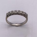 A Round Brilliant cut diamond seven stone half eternity ring, white claw set U0shape settings to a