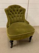 An olive button back bedroom chair on turned legs and castors (H70cm W56cm)