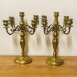 A pair of five light brass candlesticks