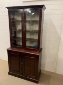 A glazed mahogany bookcase with cupboard under (H201cm W100cm D47cm)