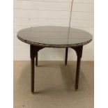 A Vincent Sheppard rattan style Lloyd Loom table with glass top (H75cm Dia90cm)