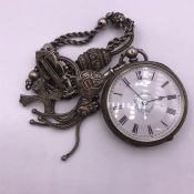 A silver pocket watch on an albert chain