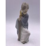 A Lladro figure of a child with a Scaff