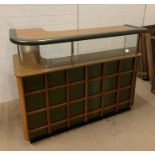 A Mid Century Bar with lattice design front and glass fronted shelves with downlighters.