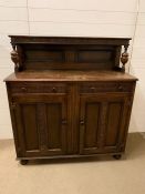 A Carved Buffet with grape and vine design, two door cupboards with shelves.(123 cm x 50 cm x 135