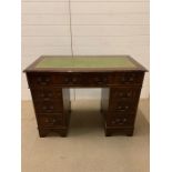 A pedestal desk with green leather top (H79cm W106cm D44cm)