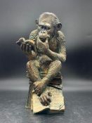 A decorative faux bronze gorilla ornament figure