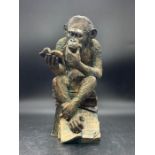 A decorative faux bronze gorilla ornament figure