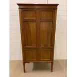 A mahogany cabinet on legs with inlaid detail