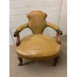 A Single leather scrolled armchair on castors