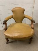 A Single leather scrolled armchair on castors
