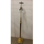 A brass floor lamp with reed column on square base