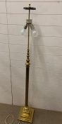 A brass floor lamp with reed column on square base