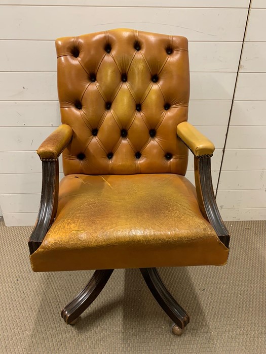 A leather button back office chair on castors