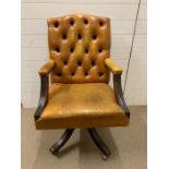 A leather button back office chair on castors