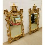 A pair of Italian giltwood wall mirrors, the shaped is a rectangular plate within a profusely carved