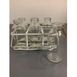 Six miniature glass bottles in wire carrying rack