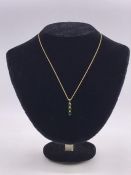A 9ct gold and emerald three stone pendant with gold neck chain on a bolt ring clasp detailed 375.(